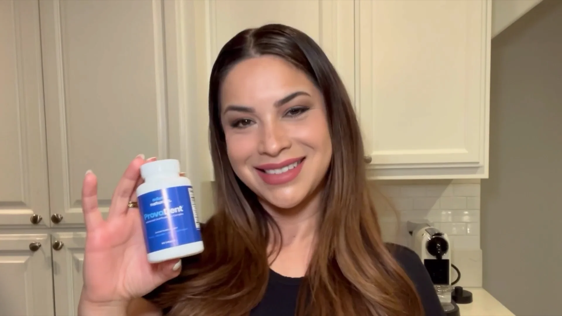 Smiling woman holding a bottle of ProvaDent, possibly sharing her experience or recommending the product for oral health.