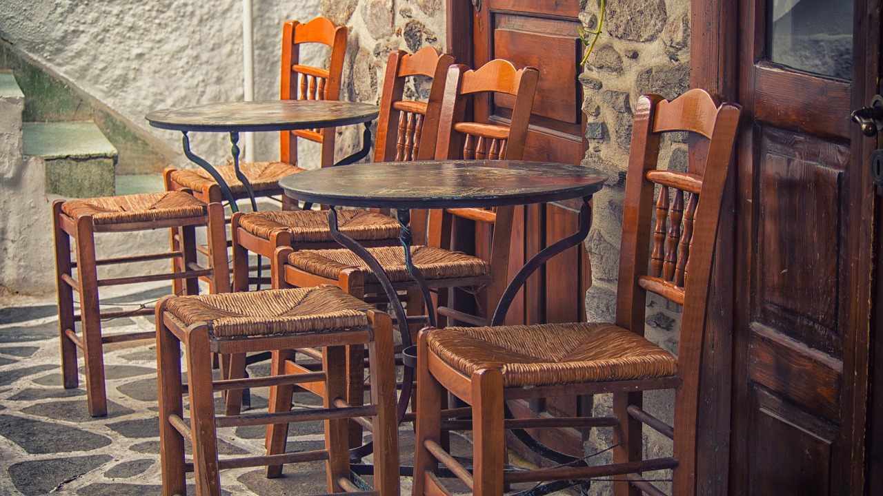 An outdoor area with a wooden table and chairs on a patio.