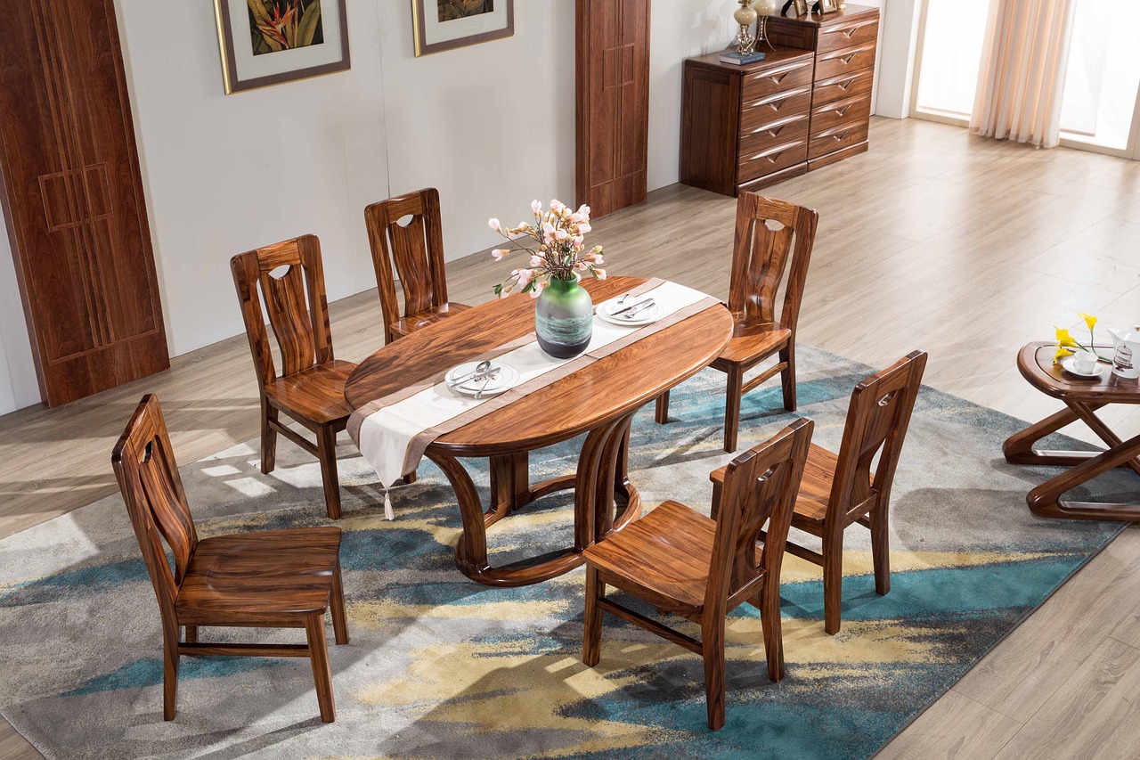 A dining room with a rustic wooden table and chairs with several shelves.
