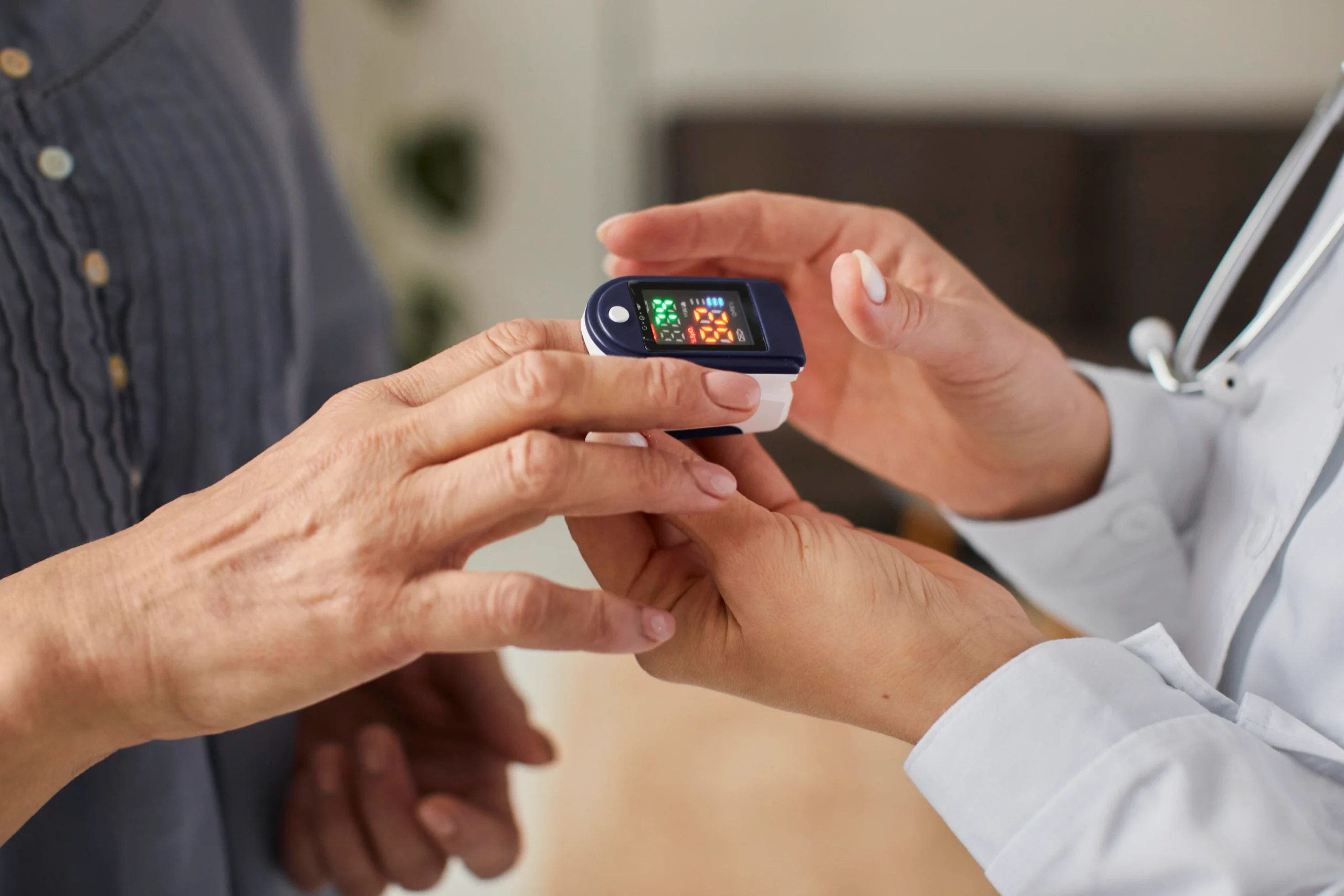 Blood oxygen measurement of elderly patient by healthcare professional, chronic disease monitoring in North America.