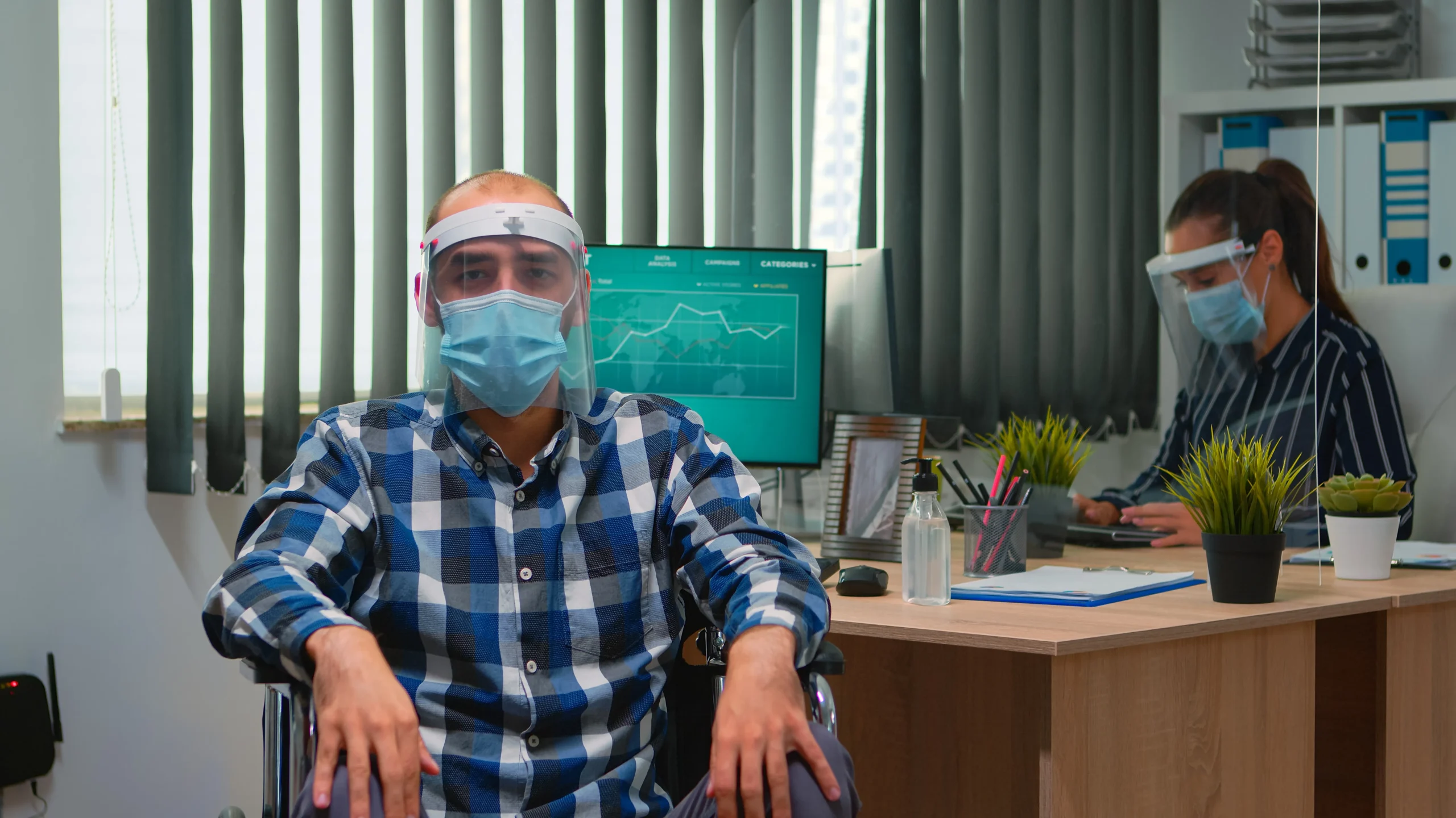 Two healthcare workers wearing face shields and masks look at a computer screen displaying medical data and charts. The text overlay reads: "Technological Advancements Shaping Elderly Care. The increase in the 65-and-over age group is partly due to technological and medical advancements that enable seniors to live longer, healthier lives. In fact, seniors in developed countries like the U.S. can expect to spend more than a quarter of their lives beyond the age of 65. Yet, this demographic change has placed significant pressure on healthcare and social service systems, calling for innovative approaches to elderly care."